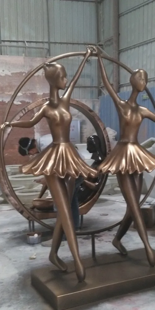 The fiberglass copper-like two female dancer sculptures which are being made in the factory